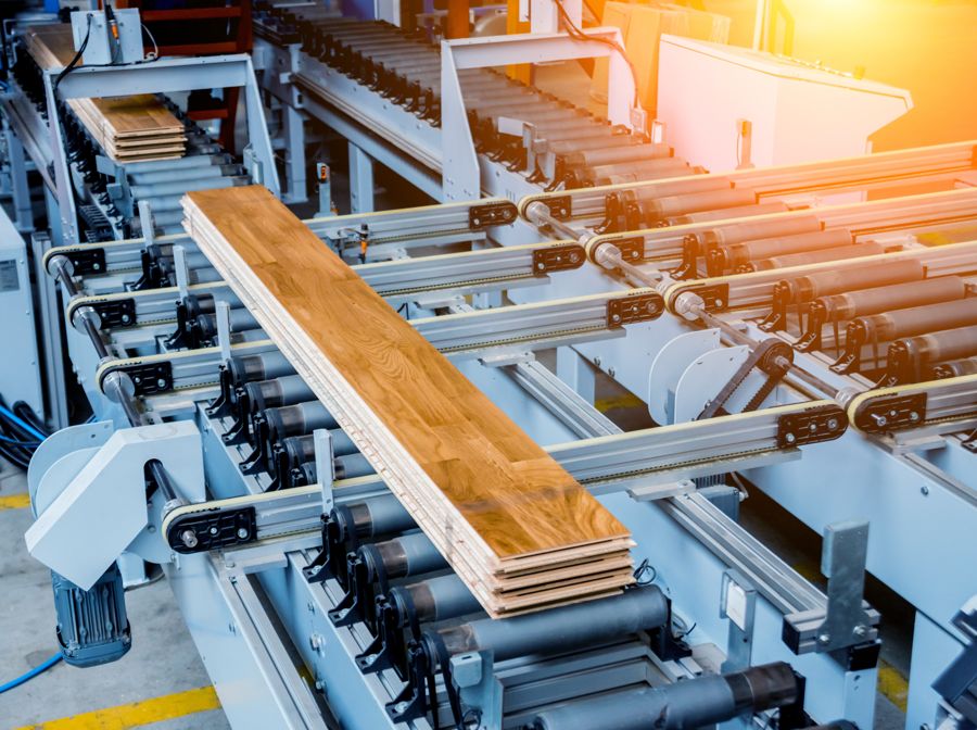 Stack of flooring boards on a roller conveyor line