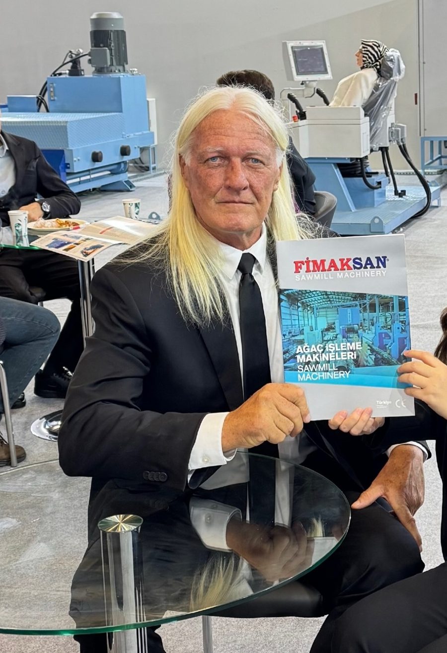 Larry Lawrence of Euro-Wood holding a Fimaksan sawmill machinery catalog at a trade show